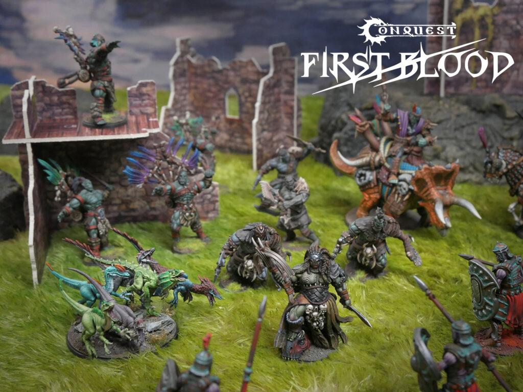 Tabletop battle scene with diverse fantasy miniatures clashing on a grassy battlefield beside ruined stone walls; Conquest First Blood logo in the upper-right corner.