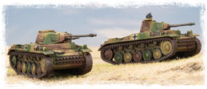 Two camouflage-pattern model tanks on a grassy field under a blue sky.