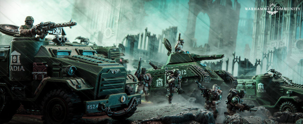 Armored troops and green battle tanks advance through a ruined city with smoke and rubble; Warhammer Community logo in the corner.