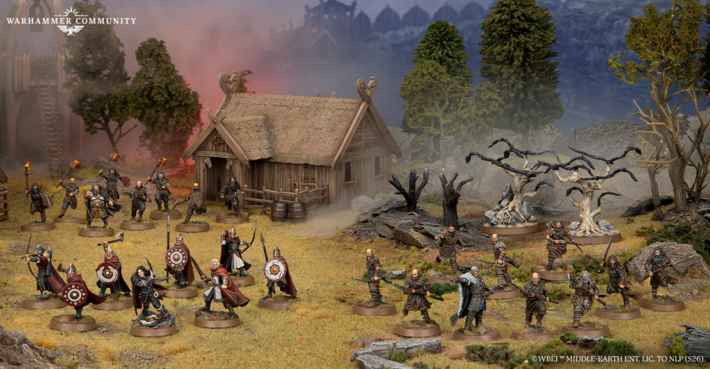 Tabletop Warhammer siege scene with armored warriors attacking a thatched cottage amid smoke and trees.