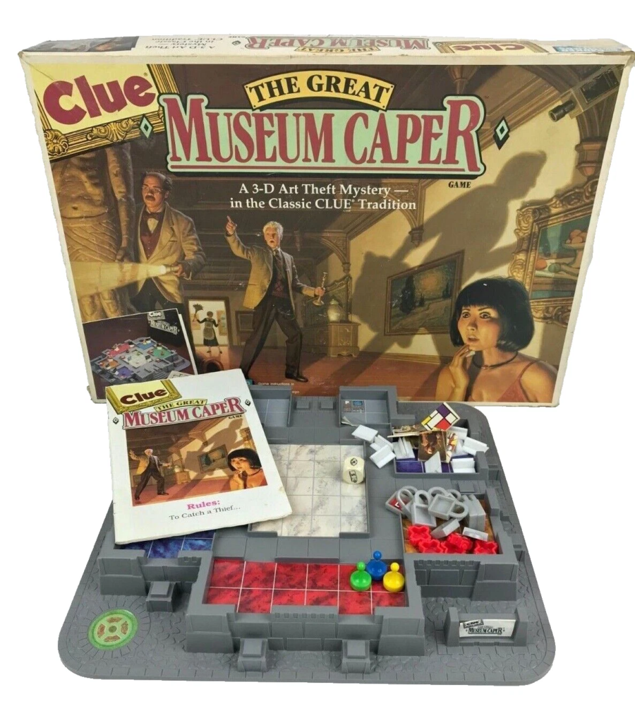 Box for Clue: The Great Museum Caper board game, opened to show the modular gray game board, rules booklet, and colorful tokens and pieces laid out inside.