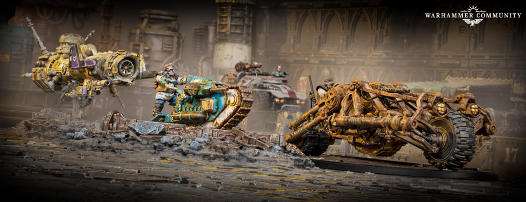 Warhammer battle scene: a yellow armored walker clashes with a teal tank amid rubble in a ruined industrial setting; Warhammer Community logo top-right.