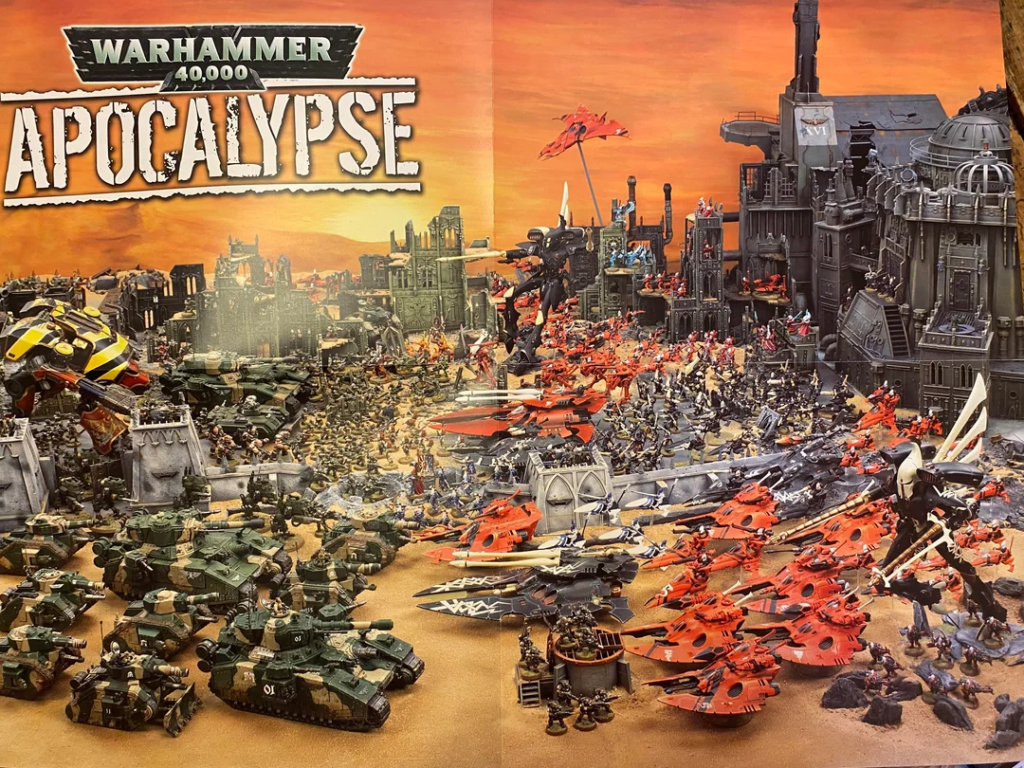 Warhammer 40,000 Apocalypse battle scene with green Imperial tanks and red xenos flyers amid a ruined cityscape.