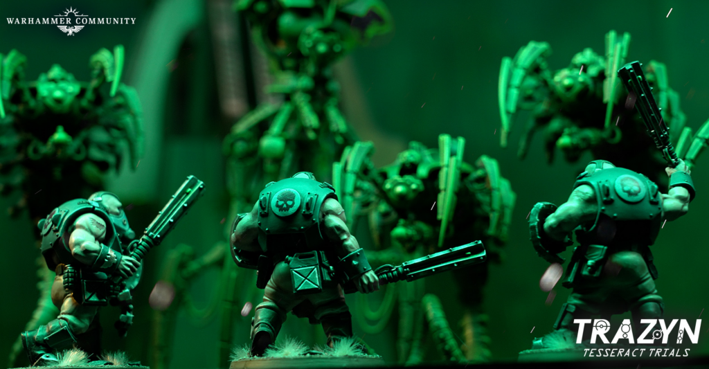 Group of green-armored Warhammer miniatures in a dynamic battle pose on a diorama, Warhammer Community logo top-left and TRAZYN logo bottom-right.