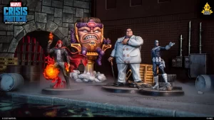Four Marvel Crisis Protocol miniatures stand in a gritty alley: a flame-wielding hero, a large orange villain, a white-suited boss with a sword, and a blue armored hero, with barrels and pipes in the background.