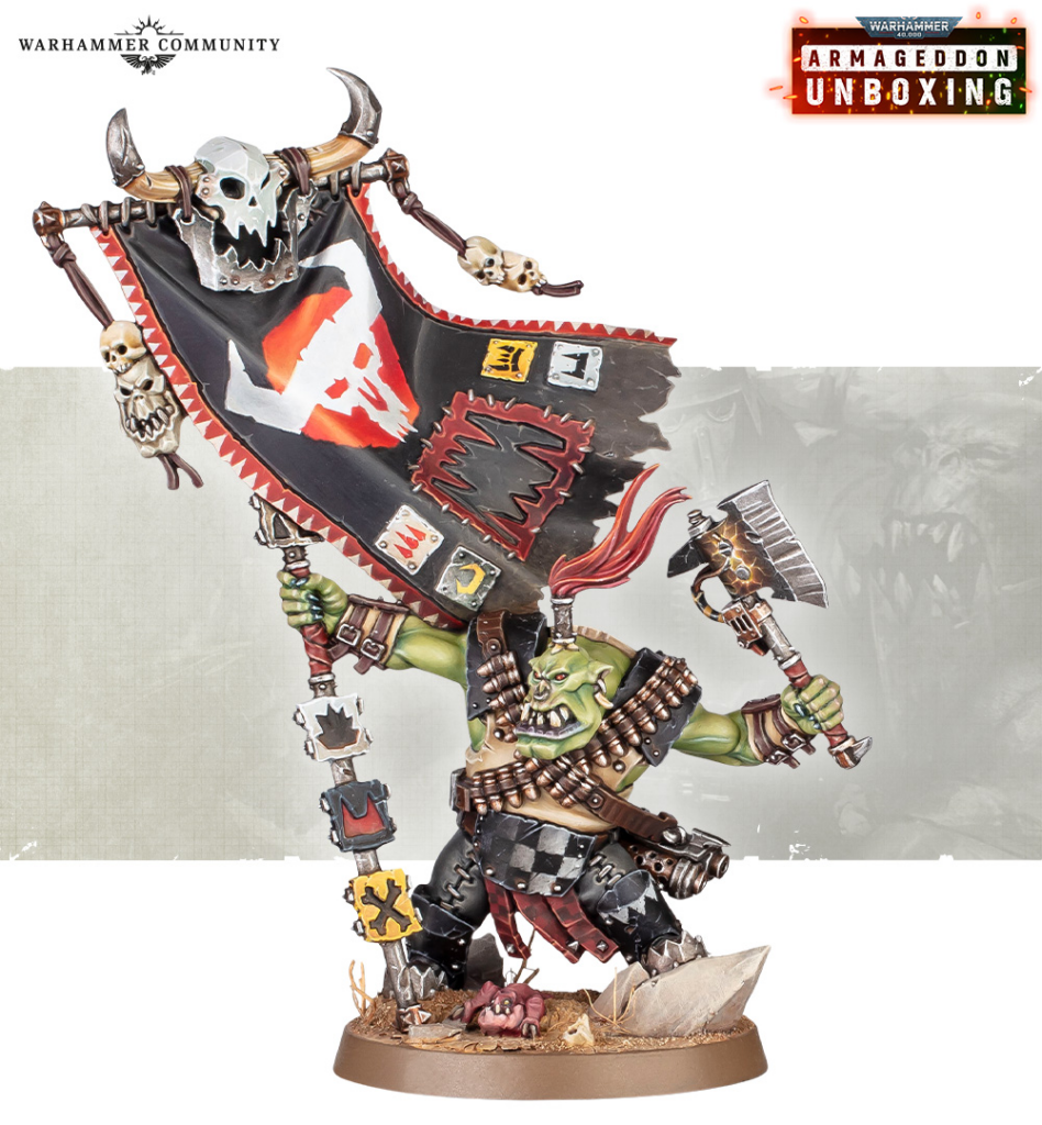 Orc warboss miniature holding a large banner adorned with skulls and spikes, wielding an axe, standing on a textured base.