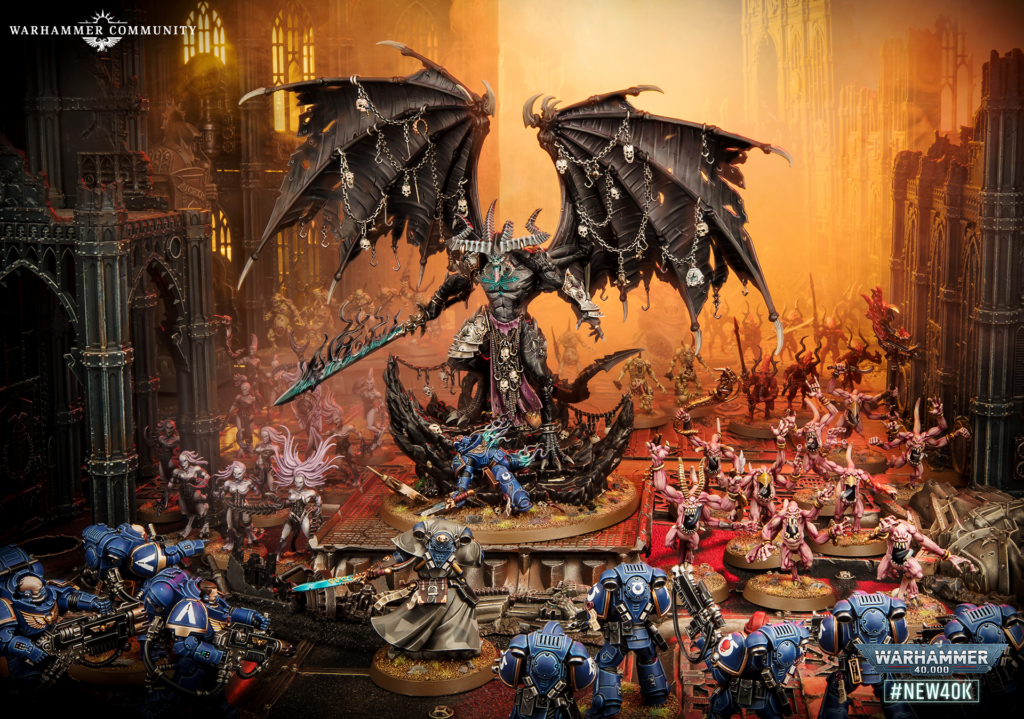 Demon lord with giant black wings and chained adornments looms over a battle of blue-armored Space Marines and pink demons amid ruined gothic ruins, with a fiery orange backdrop.