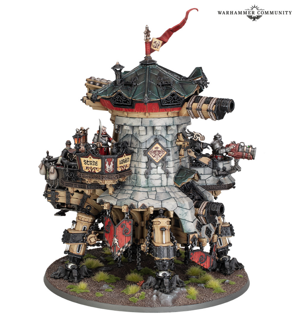 Elaborate Warhammer siege tower model with cannons, banners, and armored legs on a rocky base.