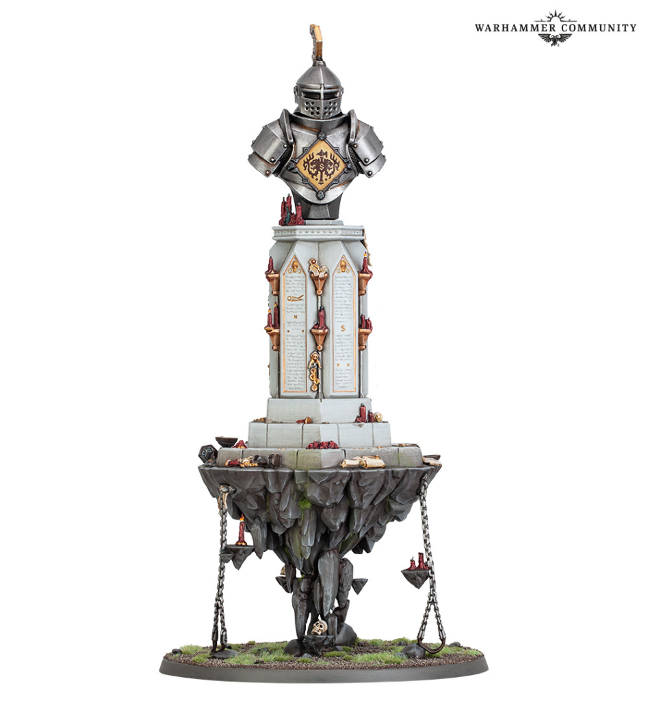 Warhammer miniature statue: armored knight bust on a tall carved pedestal above a jagged rocky base with chains and a watermark in the corner.