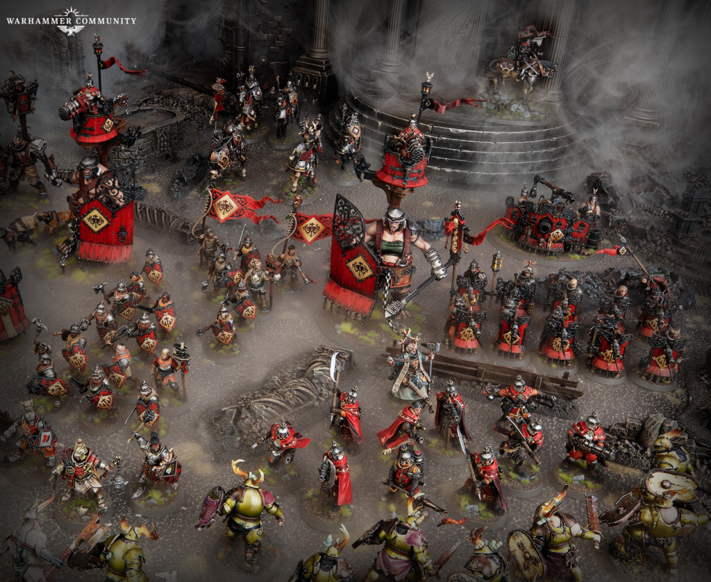 Massed Warhammer miniatures in red and gold banners clash on a ruined battlefield with smoky atmosphere.