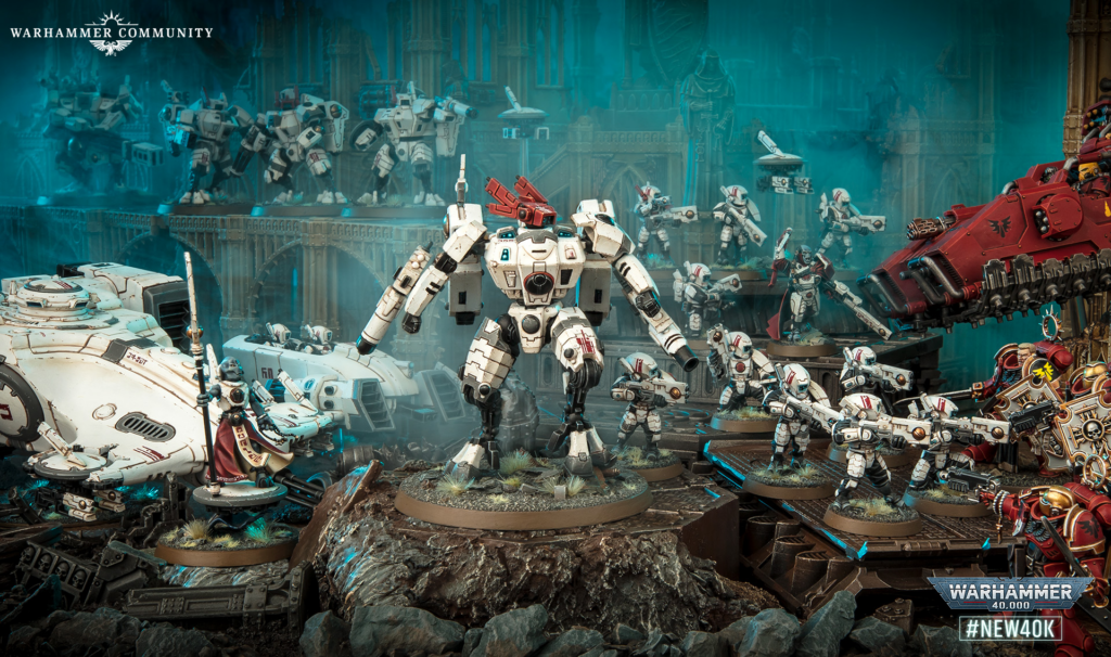 Tabletop Warhammer 40,000 battle scene with white-armored Space Marines fighting across a ruined, blue-tinged battlefield and a red siege vehicle in the background.
