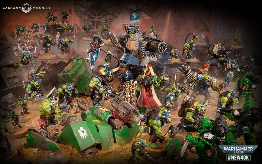 Battle scene with green Orcs and armored Marines clashing around a large siege vehicle in a ruined battlefield, Warhammer imagery.