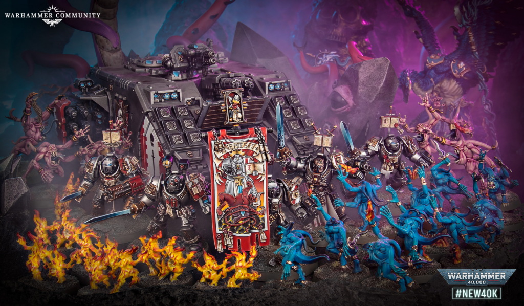 image Frontline Gaming Warhammer 40,000 battle diorama with a central heavy siege tank surrounded by blue demons and fiery foregrounds on a dark battlefield — Nemesis banner visible in front.