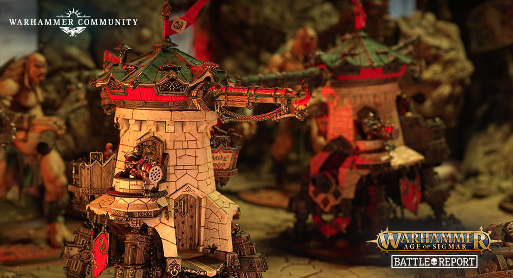 image Frontline Gaming Tabletop Warhammer Age of Sigmar battle scene with stone towers and painted miniatures; Warhammer Community branding in the corner.