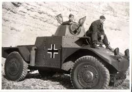 image Frontline Gaming World War II German armored car with Balkenkreuz emblem on a rocky slope, with two soldiers beside and on the vehicle.