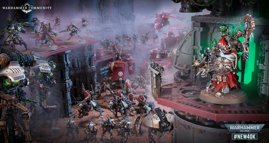 image Frontline Gaming Crowded Warhammer 40,000 battle diorama with many armored miniatures clashing in a ruined industrial setting, led by a large red-wearing warlord on a raised platform at right edge.