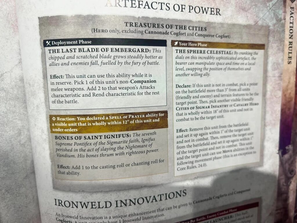 Close-up of a fantasy board game rule card, showing deployment phase and hero phase sections with descriptive text and names like 'The Last Blade of Embergrad' and 'Bones of Saint Ignifus'.