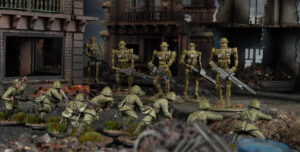 Miniature battle scene: green-clad infantry advance through rubble toward a line of gold robotic soldiers with rifles amid a ruined cityscape.