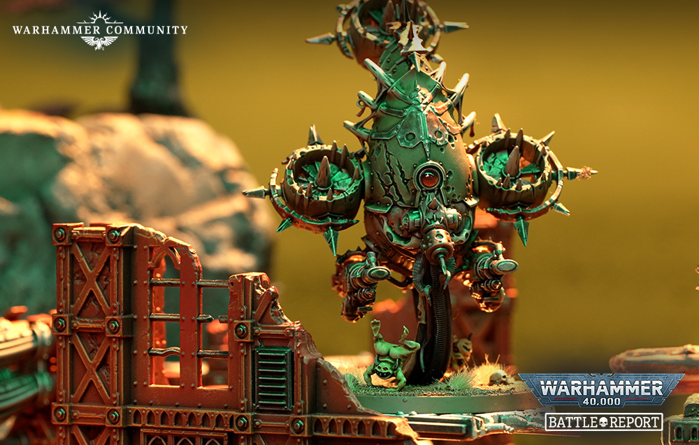 image Frontline Gaming Green spiked Warhammer 40,000 war machine looms over a ruined red-brown platform; Warhammer Battle Report badge and Warhammer Community logo visible.
