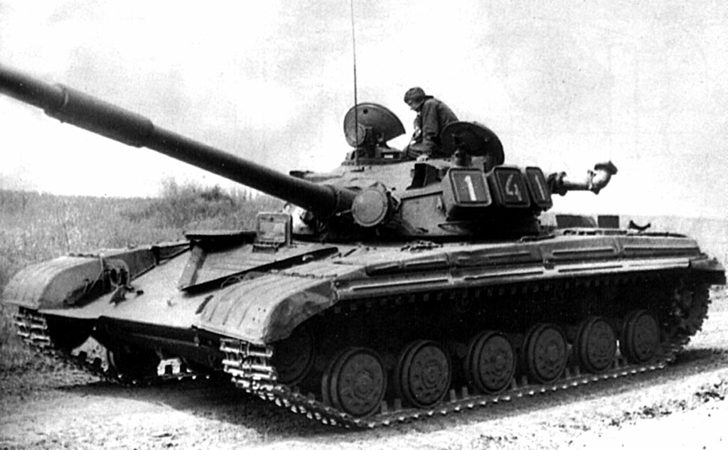 image Frontline Gaming World War II era tank with long gun, a crew member in the turret hatch on top.