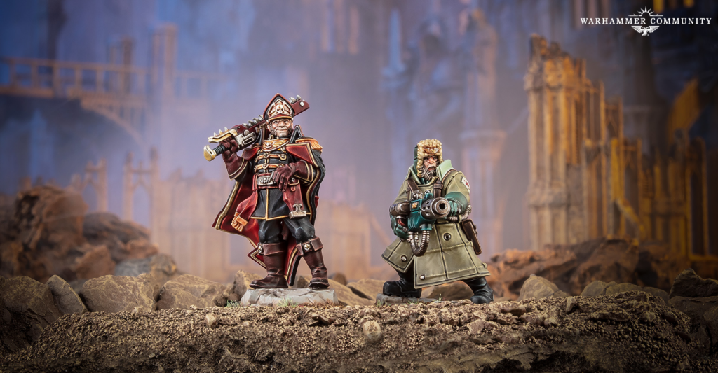 image Frontline Gaming Two painted Warhammer miniatures stand on rocky ground in a ruined battlefield setting with blue mist behind them.