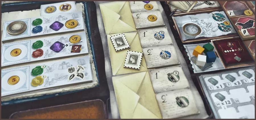 image Frontline Gaming Board game setup with envelopes, cards, dice-like tokens and colorful game pieces laid out on a table.