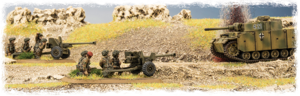 Scale-model World War II diorama: a camouflaged German tank approaches as artillery crews prepare a towed cannon on a rocky field widowed by trenches and grass.