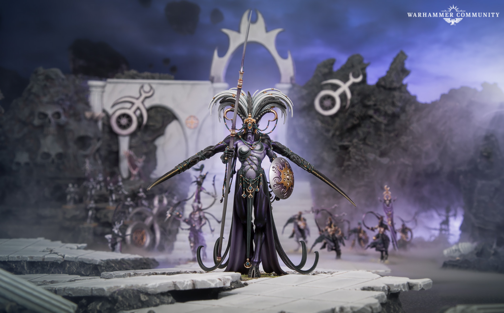 Dark fantasy Warhammer miniature stands on ruined stone platform, wielding a spear with an ornate feathered helm and shield amid purple mist.
