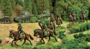 Model military diorama soldiers on horseback advancing through a forested landscape with tanks in the background