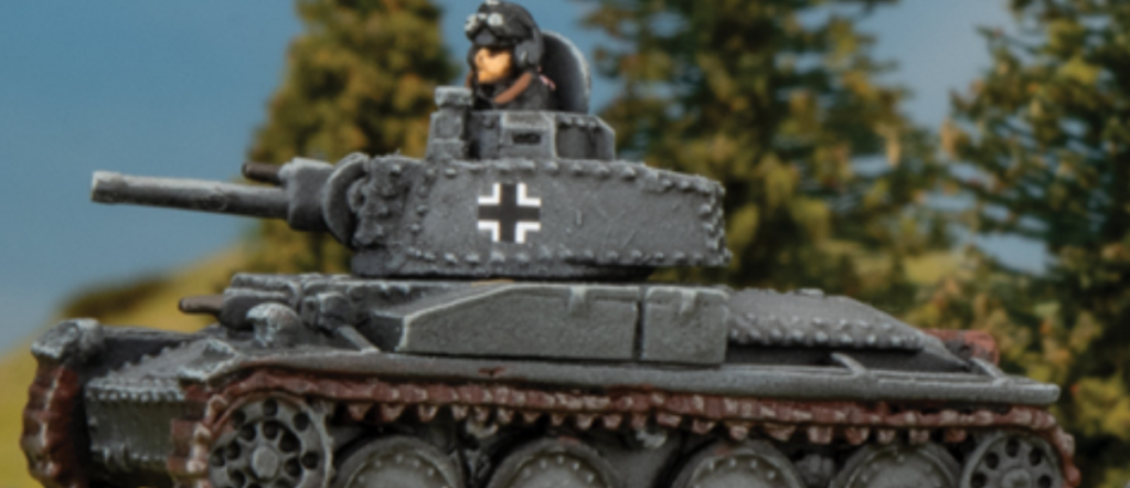 Scale model of a WWII German tank with a crewman figure, displaying a white cross insignia, on a forest backdrop