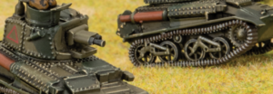 Two detailed miniature tanks with riveted armor and visible tracks resting on a grassy field