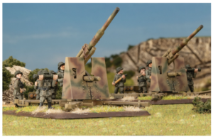 Scale model battlefield diorama showing camouflaged towed anti tank guns with soldiers on a grassy rocky terrain