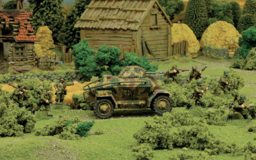 World War II diorama German soldiers advance with an armored car through a rural village scene of huts and bushes