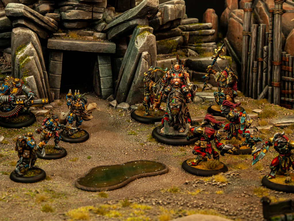 Group of painted fantasy miniatures on a rocky battlefield with a ruined stone doorway in the background