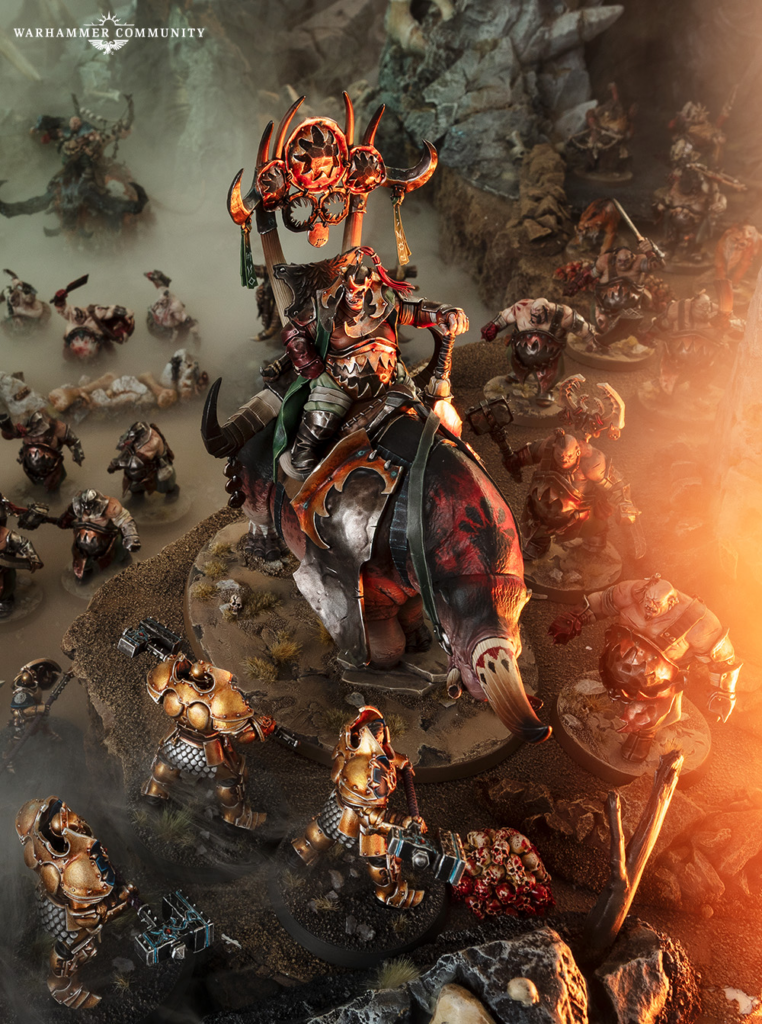 image Frontline Gaming Chaos warrior on a large beast leads a tabletop battle among armored infantry on a rocky diorama with a Warhammer theme