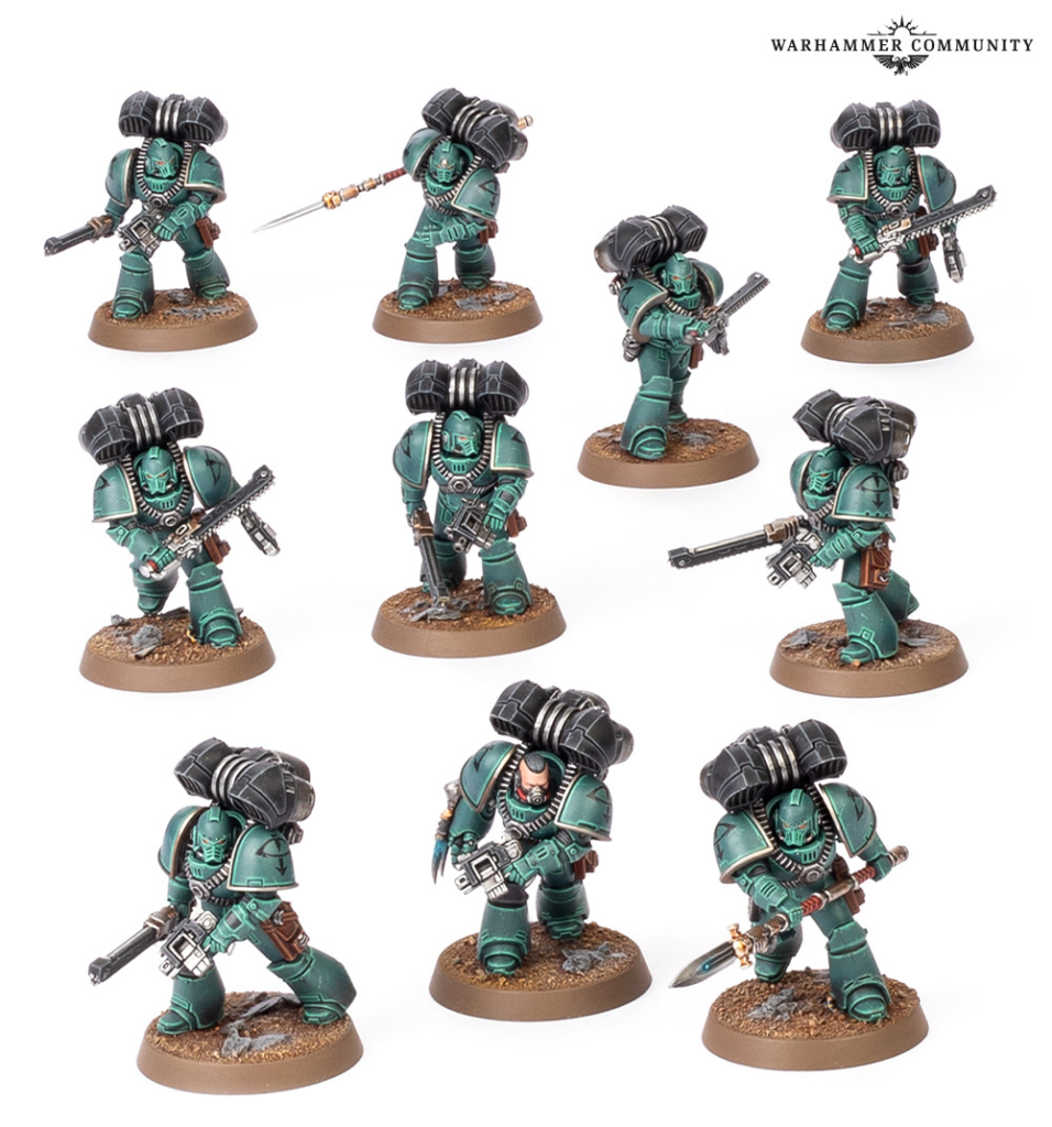image Frontline Gaming Eight teal green Space Marines in power armor posing with rifles and swords on brown bases arranged on a white background with a Warhammer Community logo in the corner