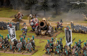 Massed Warhammer miniatures clash in a grassy field teal armored infantry advance toward a central ornate cannon with banners and a stone fence in the foreground