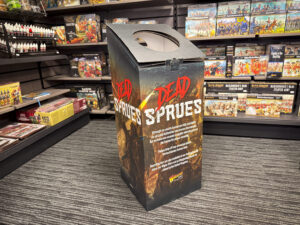 Tall display box reading DEAD SPRUES in a hobby store with model kits on shelves behind
