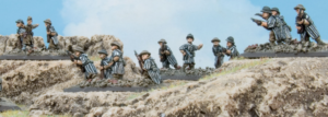 Miniature WWI soldiers in a rocky trench aiming rifles and taking cover beneath a blue sky