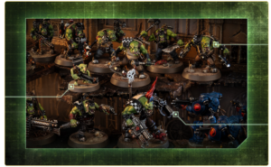 Tabletop miniature battle scene with green orc warriors fighting blue armored bots on a detailed diorama battlefield