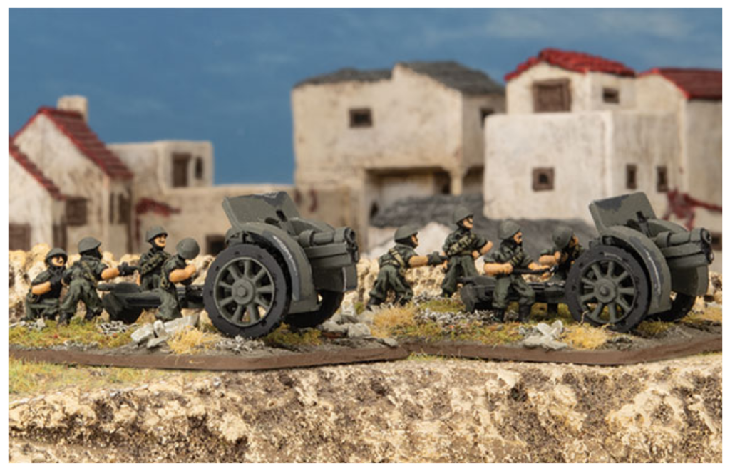 Plastic toy soldiers push a large cannon across a rubble strewn battlefield with ruined buildings in the background