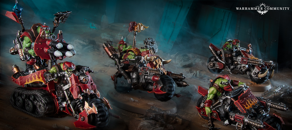 Ork riders on heavily armed red bikes charge across a smoky war torn landscape Warhammer Community logo in the top right