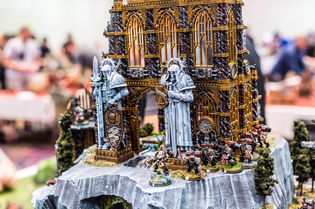 image Frontline Gaming Ornate fantasy diorama gilded gothic castle with blue armored knights and a group of miniature soldiers on a rocky base