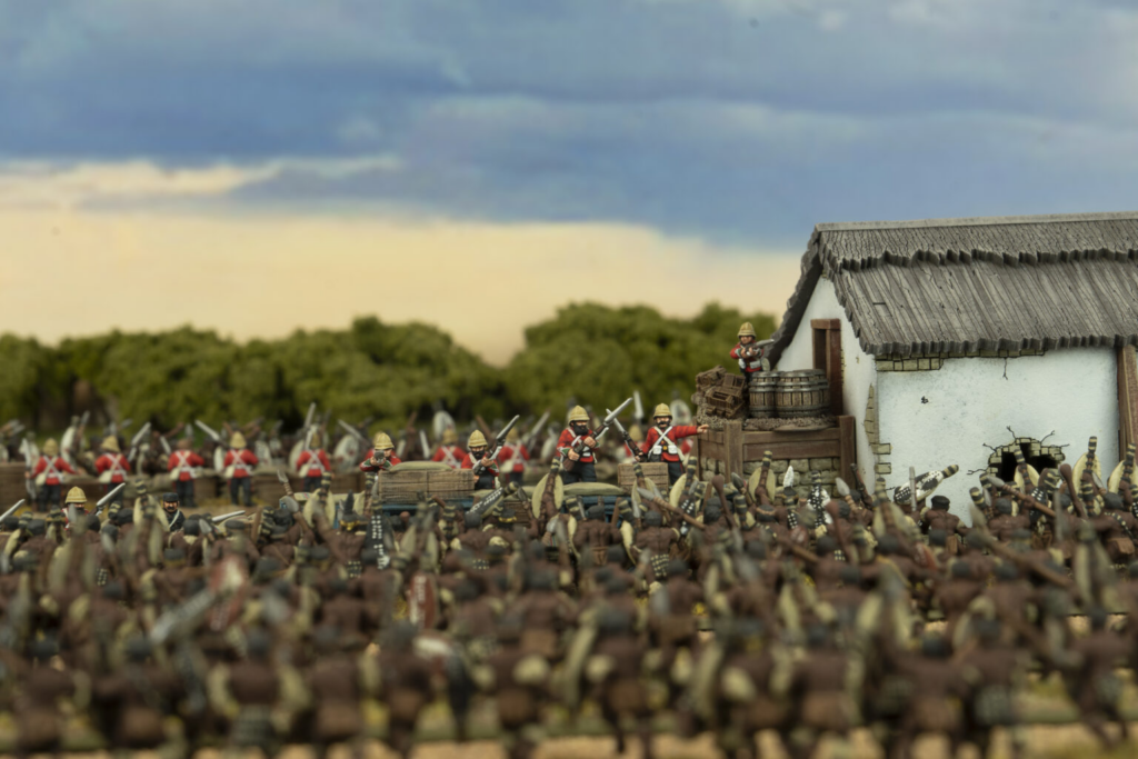 image Frontline Gaming Miniature wargame scene red uniform soldiers advance toward a white thatched roof building amid a crowded battlefield diorama