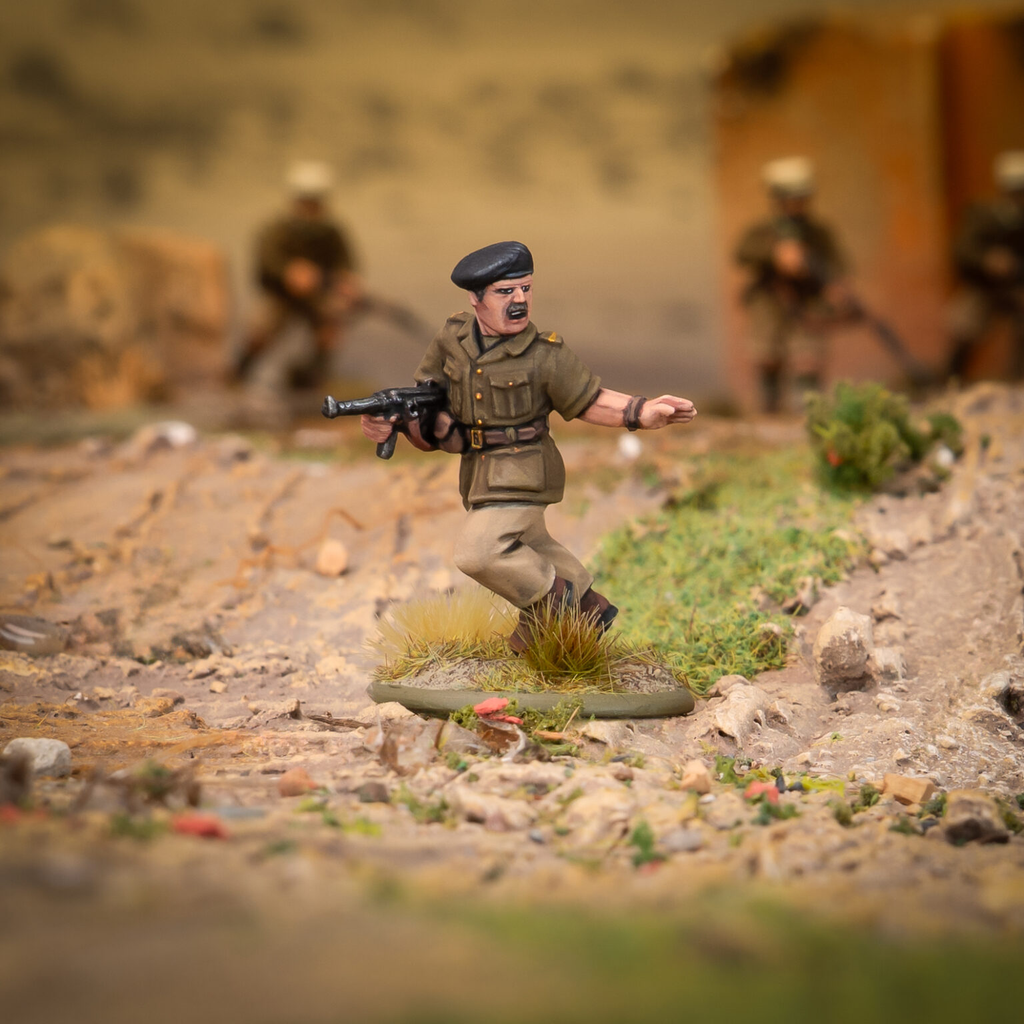 Toy soldier figurine in a dusty battlefield running with a rifle in a green uniform and black beret blurred background soldiers