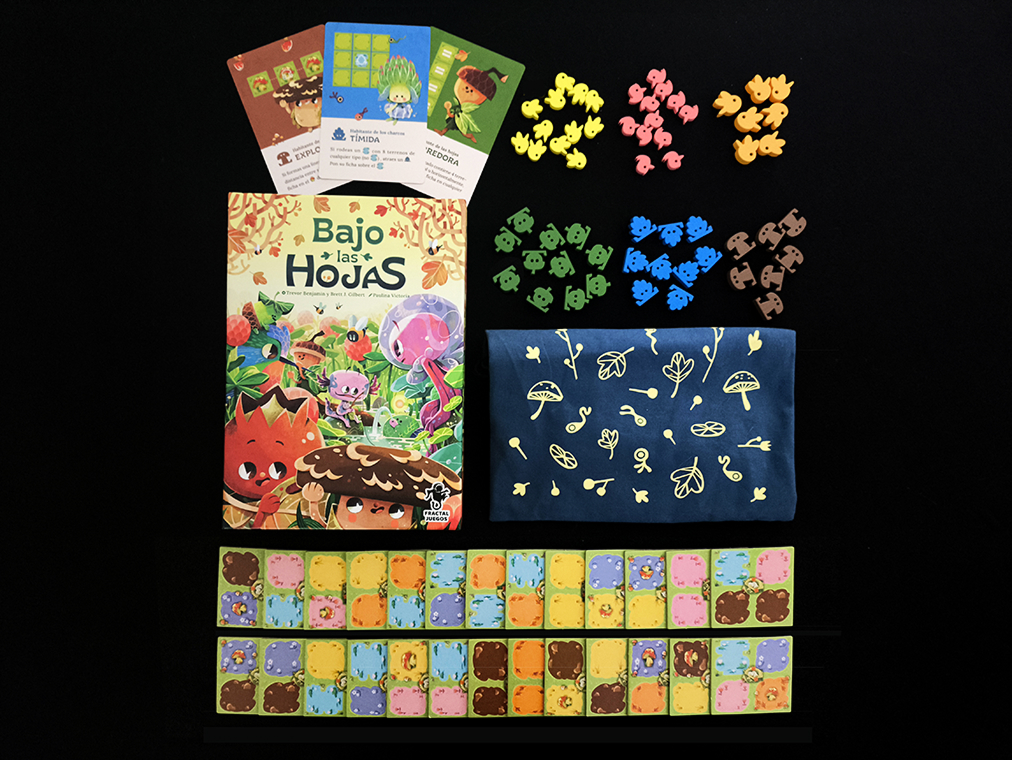image Frontline Gaming Tabletop game components colorful cards animal shaped tokens tile sheets game box of Bajo las Hojas fabric bag on a black surface