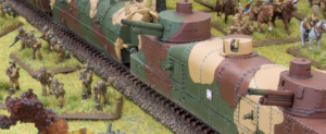 Scale model of a camouflaged armored train on a diorama with grouped toy soldiers on a grassy battlefield