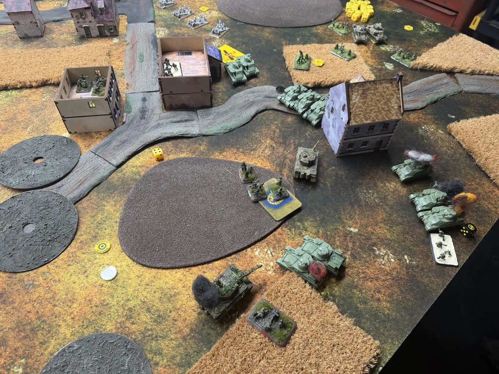 image Frontline Gaming Tabletop wargame battlefield with green armored vehicles ruined buildings roads and scattered dice on a textured mat