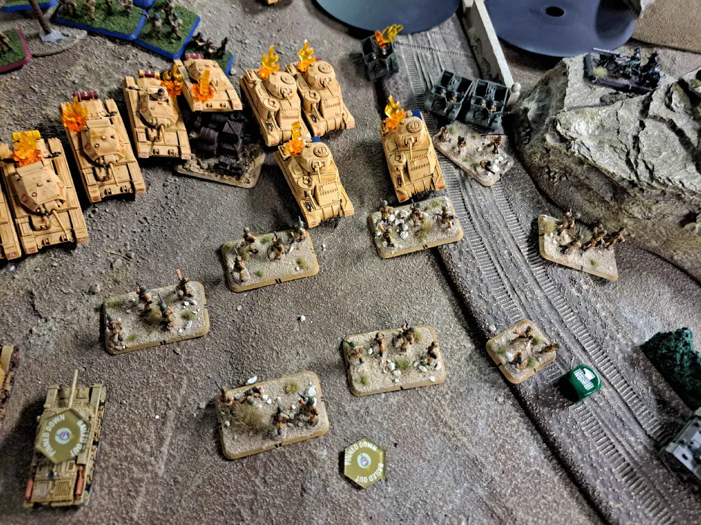 image Frontline Gaming Tabletop wargame scene with tan armored vehicles lined up and scattered basing on a textured battlefield
