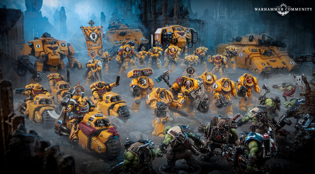 40kupdateoct29image1wideetojihy2fx Frontline Gaming Epic Warhammer 40k battle scene orange Imperial Fists Space Marines clash with green orcs in a ruined city smoke and ruined architecture in the background Warhammer Community logo upper right
